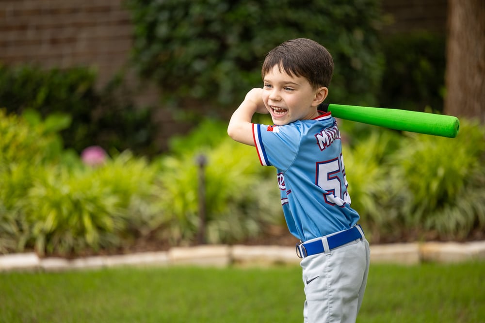 child playing baseball green lawn landscape beds 1
