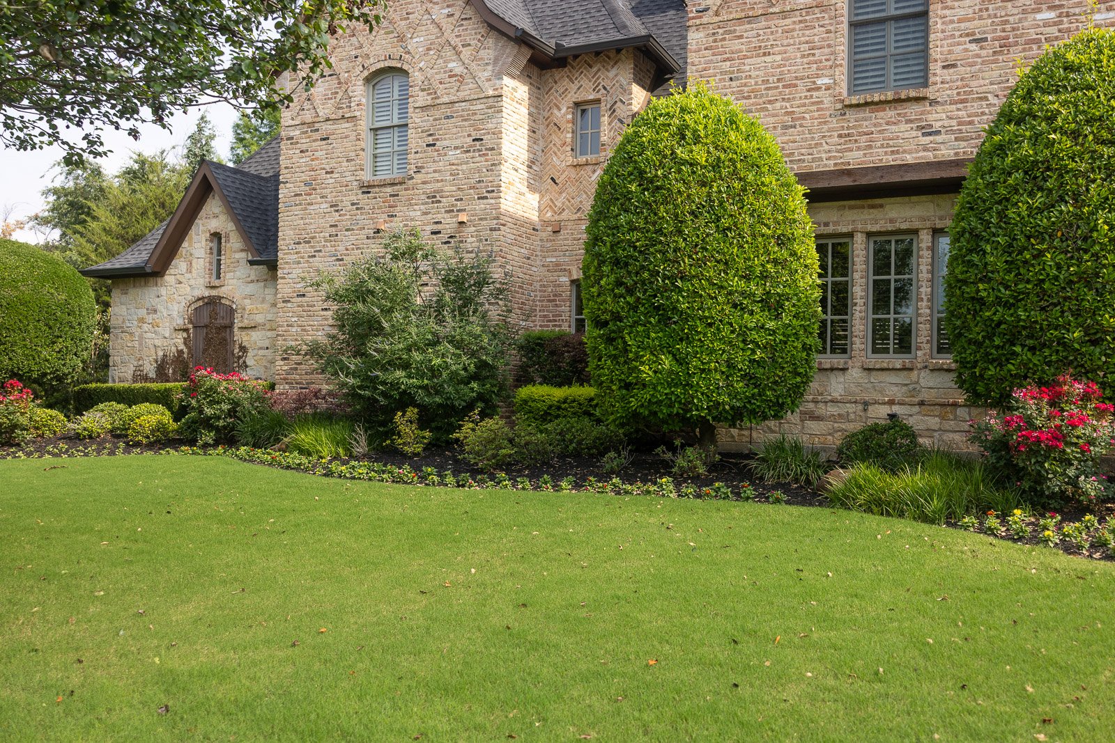 landscape beds and green lawn along house