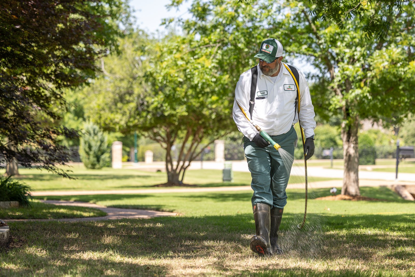 lawn care technicial putting down weed control on grass 