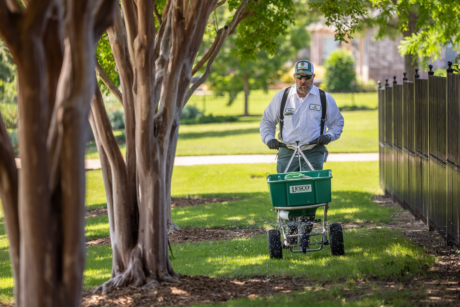 lawn care technicial putting down weed control on grass 1-1
