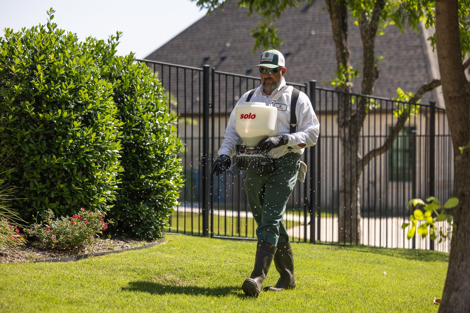lawn care technicial putting down weed control on grass 1