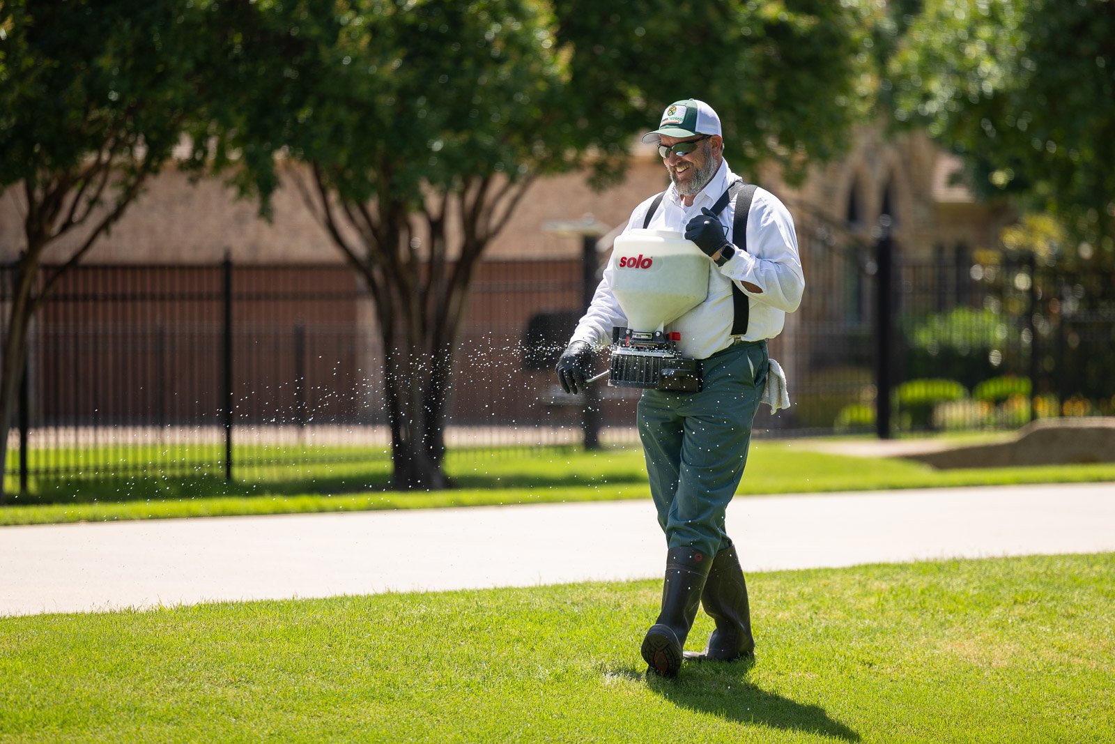 lawn care technicial putting down weed control on grass 3-1