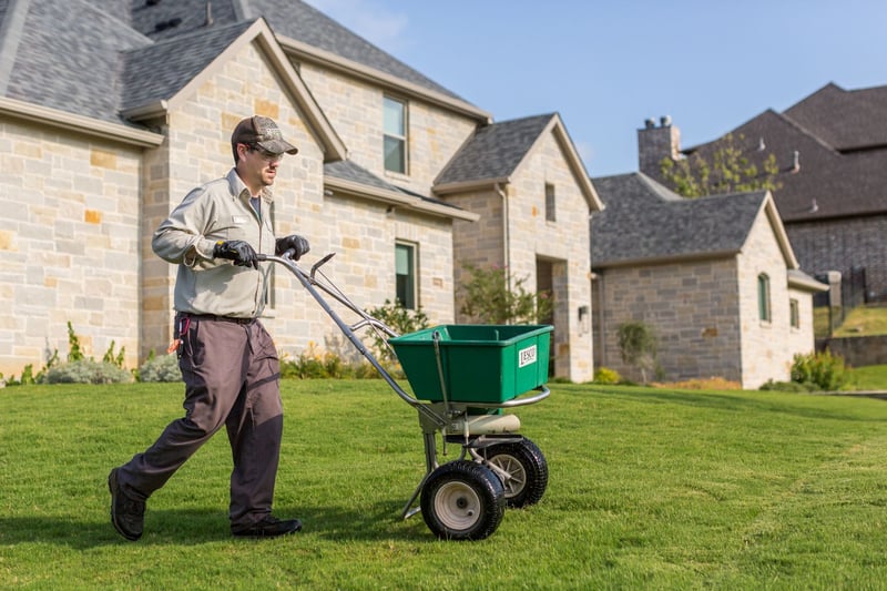 lawn care technician applying fertilizer