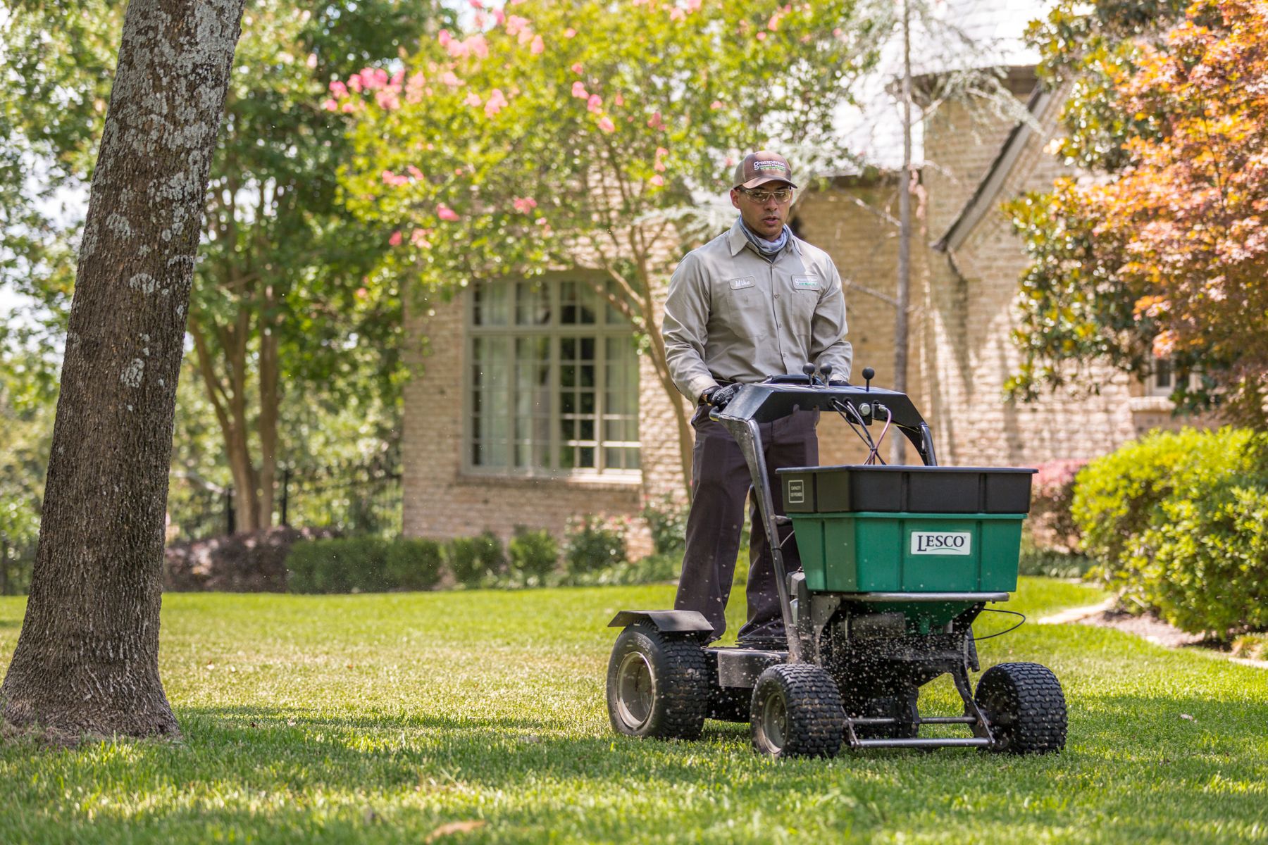lawn care technician applying fertilizer in North Texas