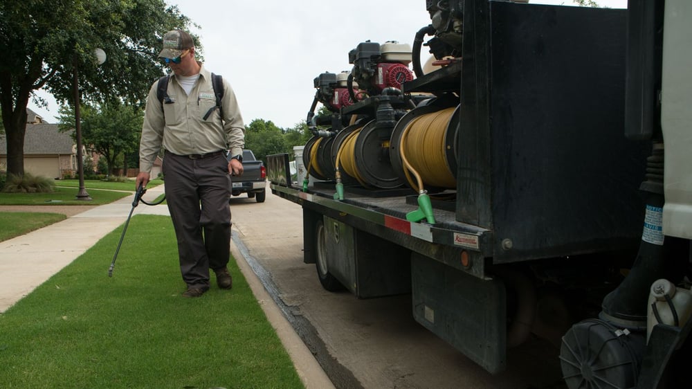 Weed control technician spraying lawn