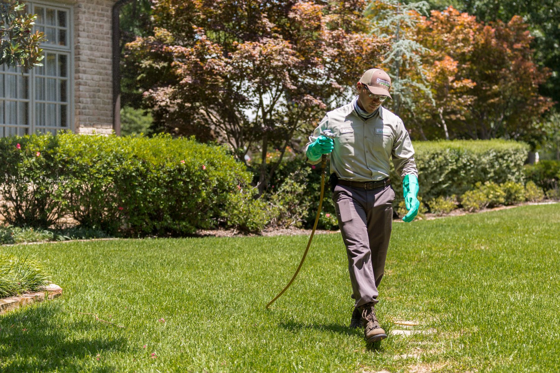 Lawn Care Technician Spraying grass