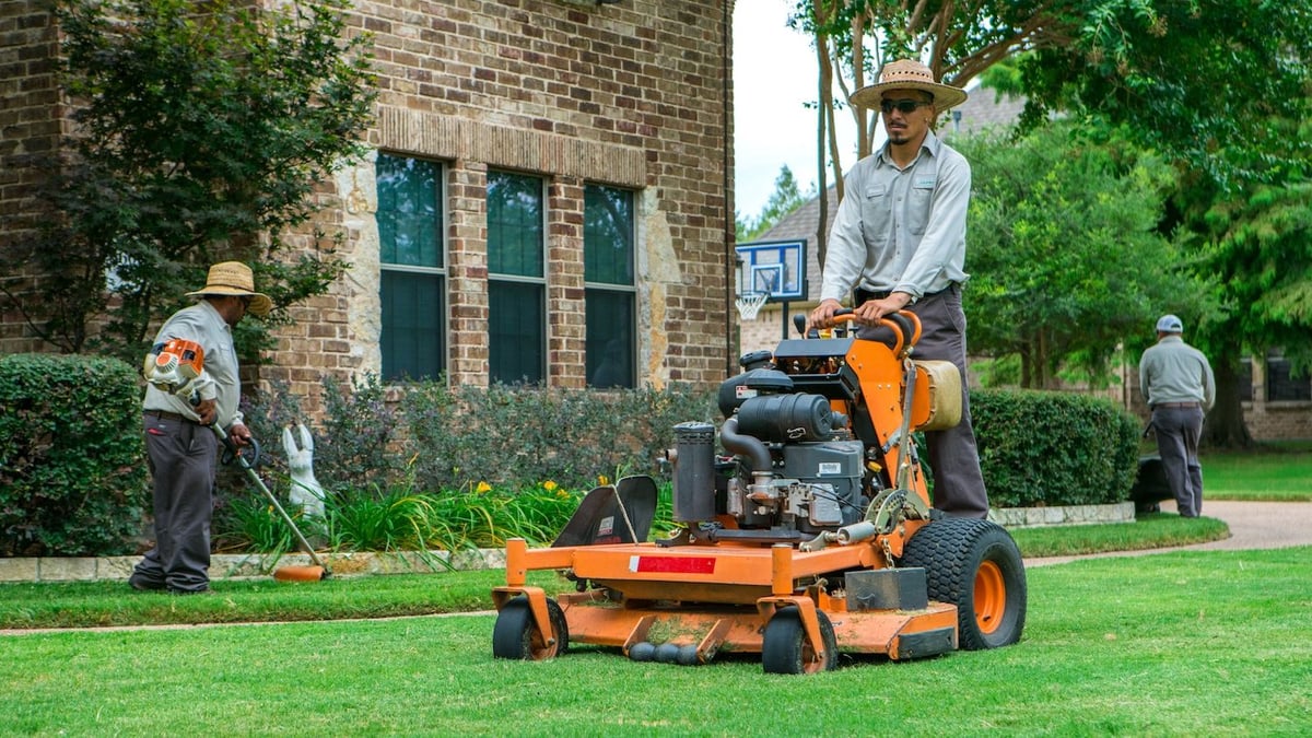lawn care team mows and trims lawn