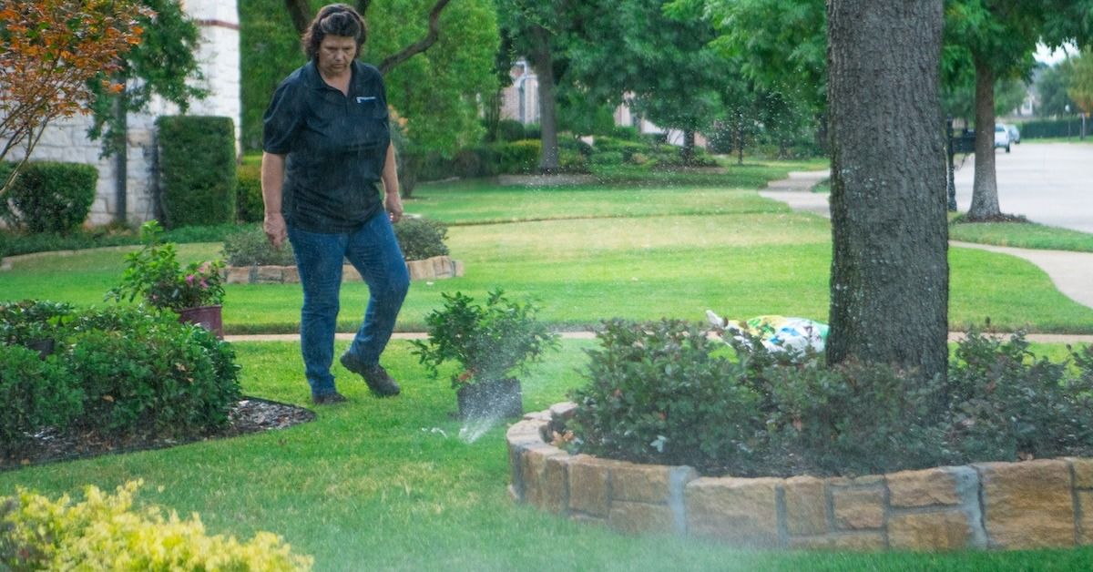 irrigation technician inspects sprinklers