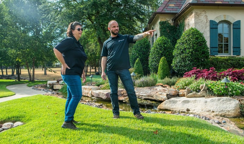 Grassperson lawn care and landscape employees in lawn