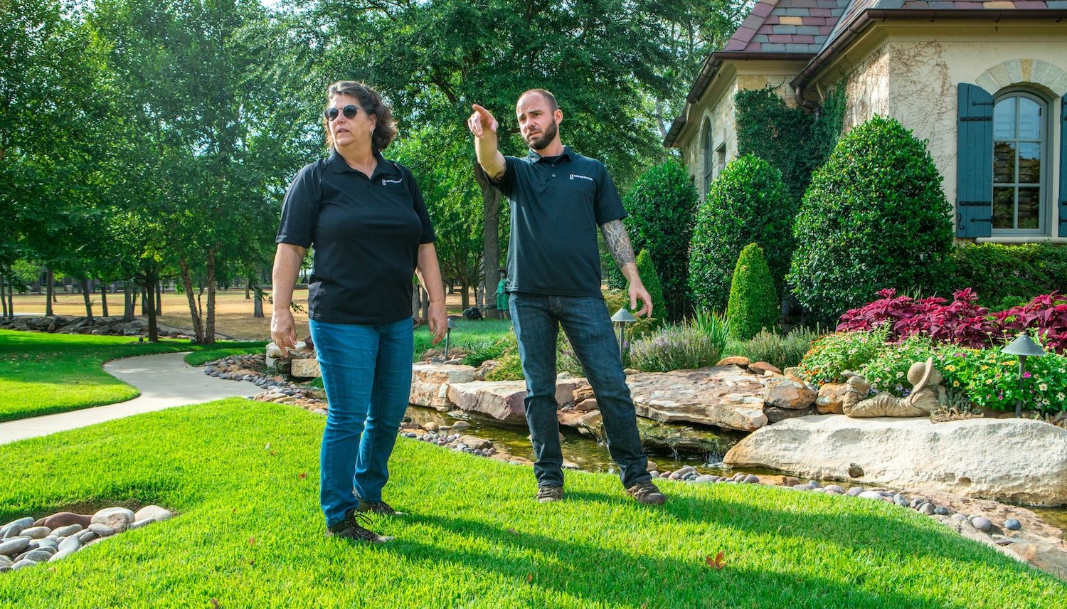 lawn care technician inspecting and diagnosing lawn problems