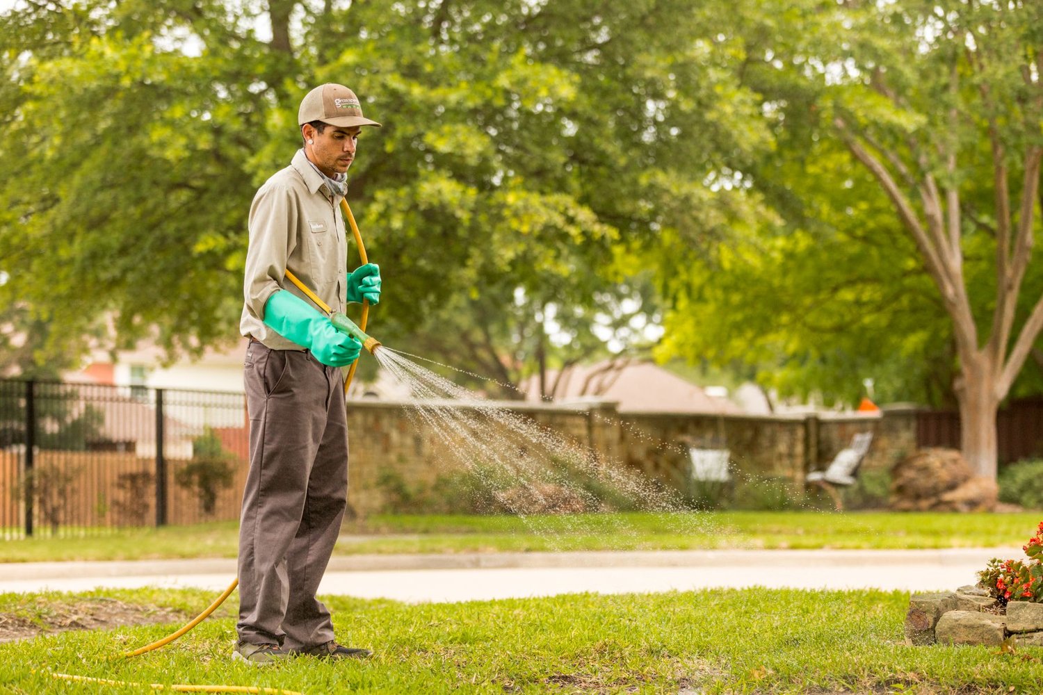 lawn care technician spraying lawn for weeds