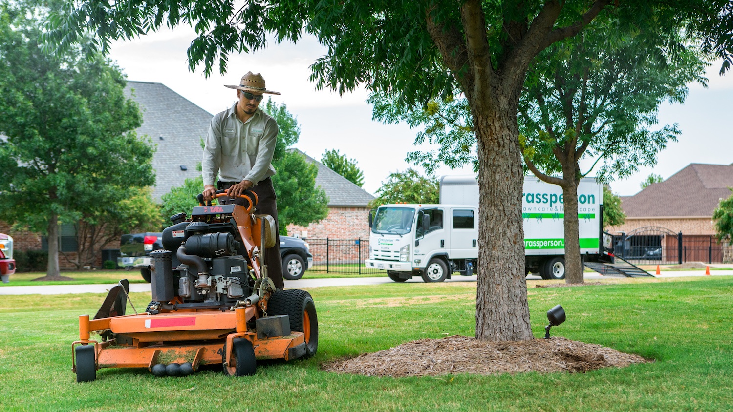Grassperson lawn technician mowing lawn