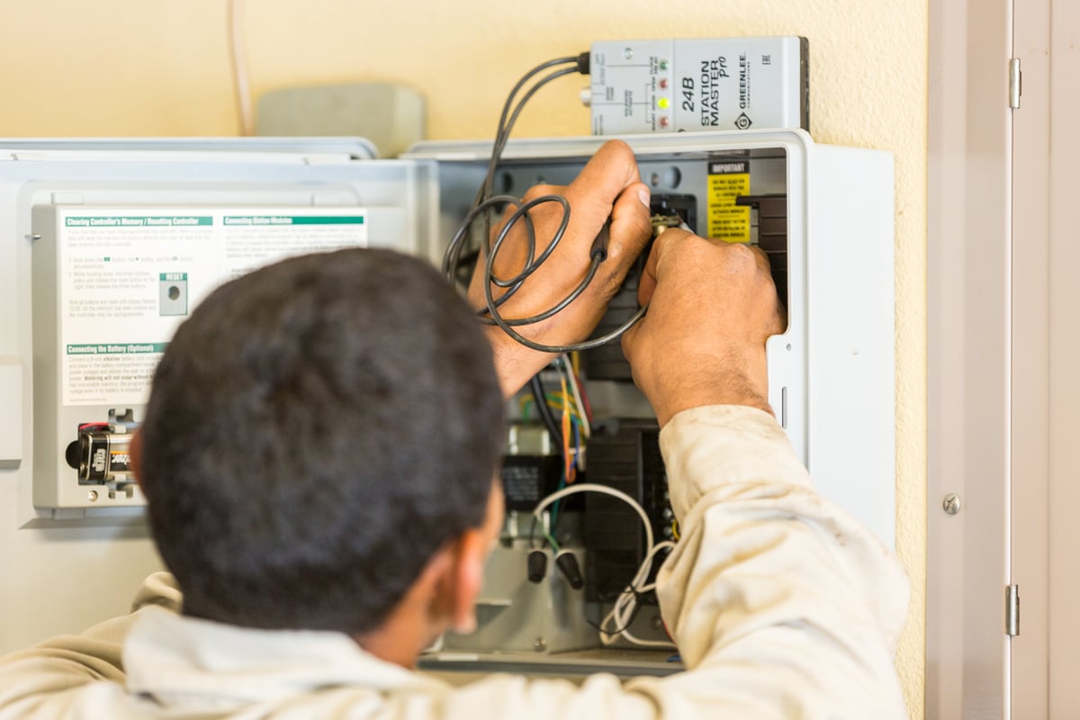 irrigation technician works on system controls