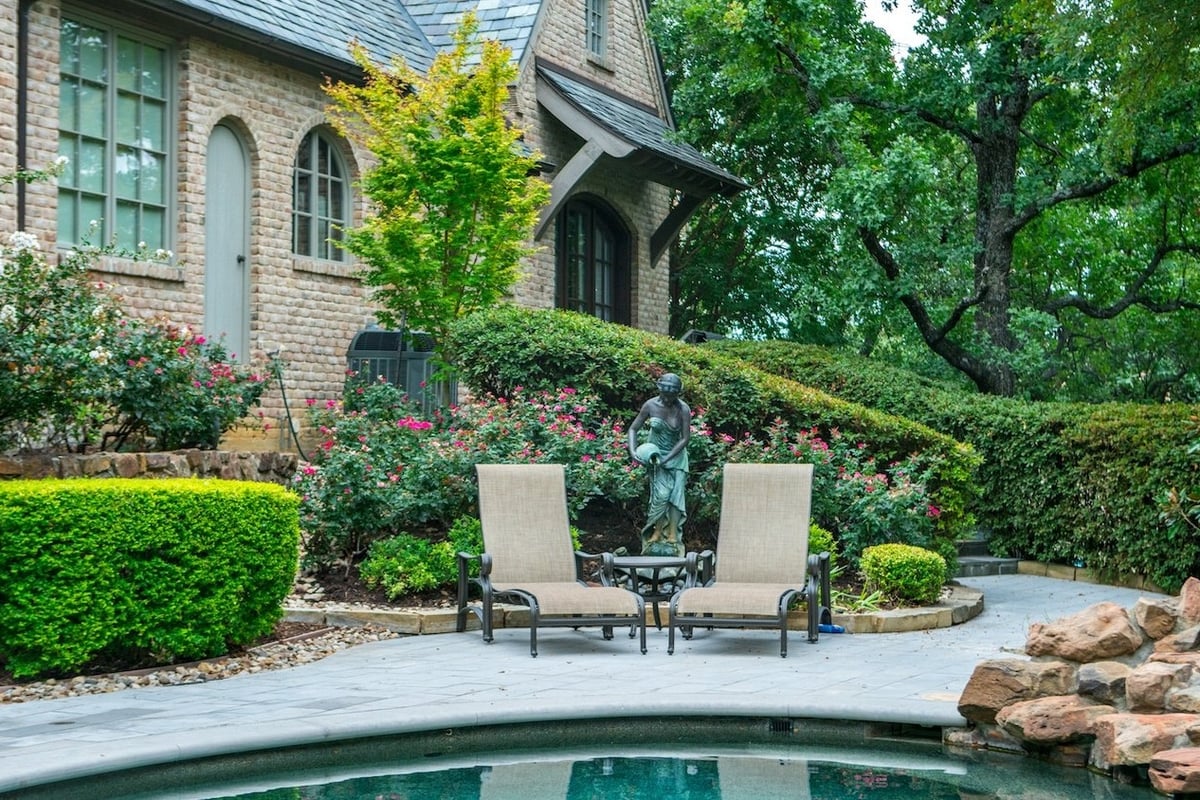 plantings and sculpture near patio with seating