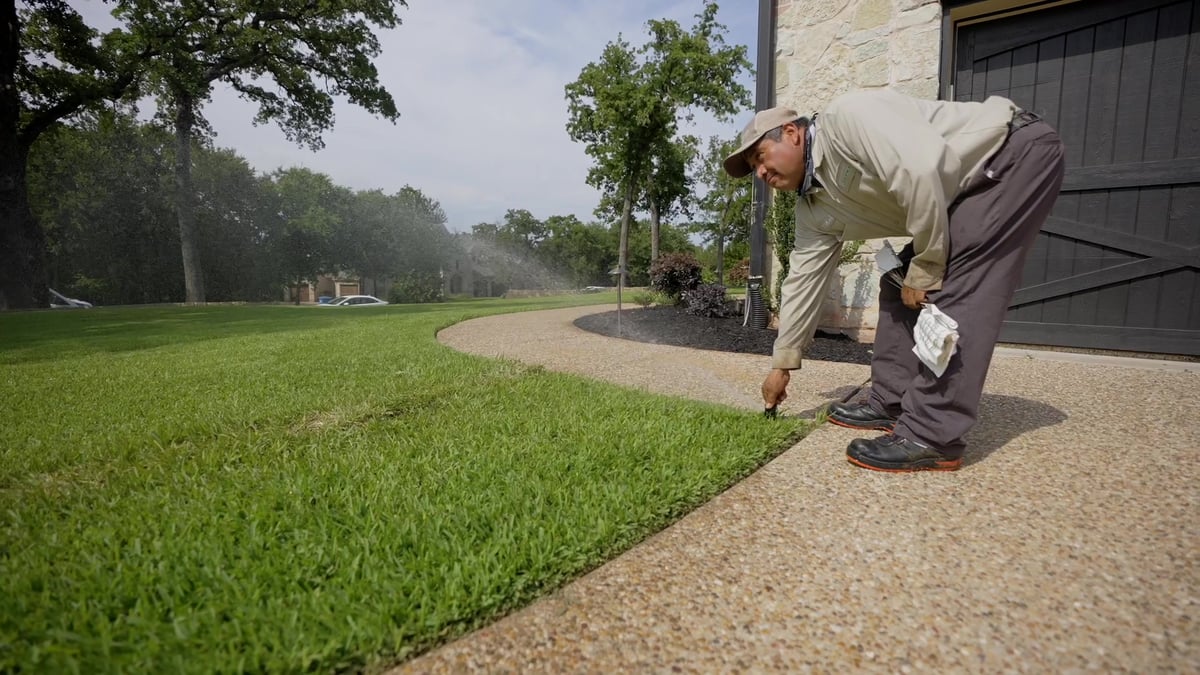 irrigation expert adjusts sprinkler head