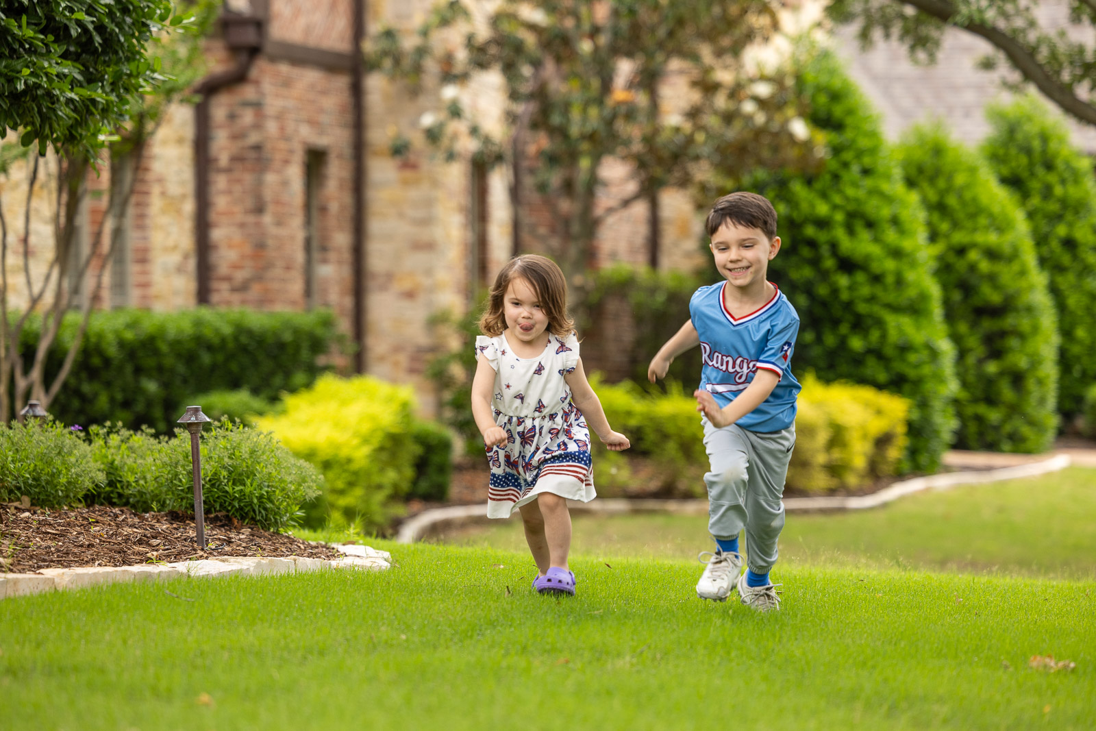 children running on green lawn landscape beds 