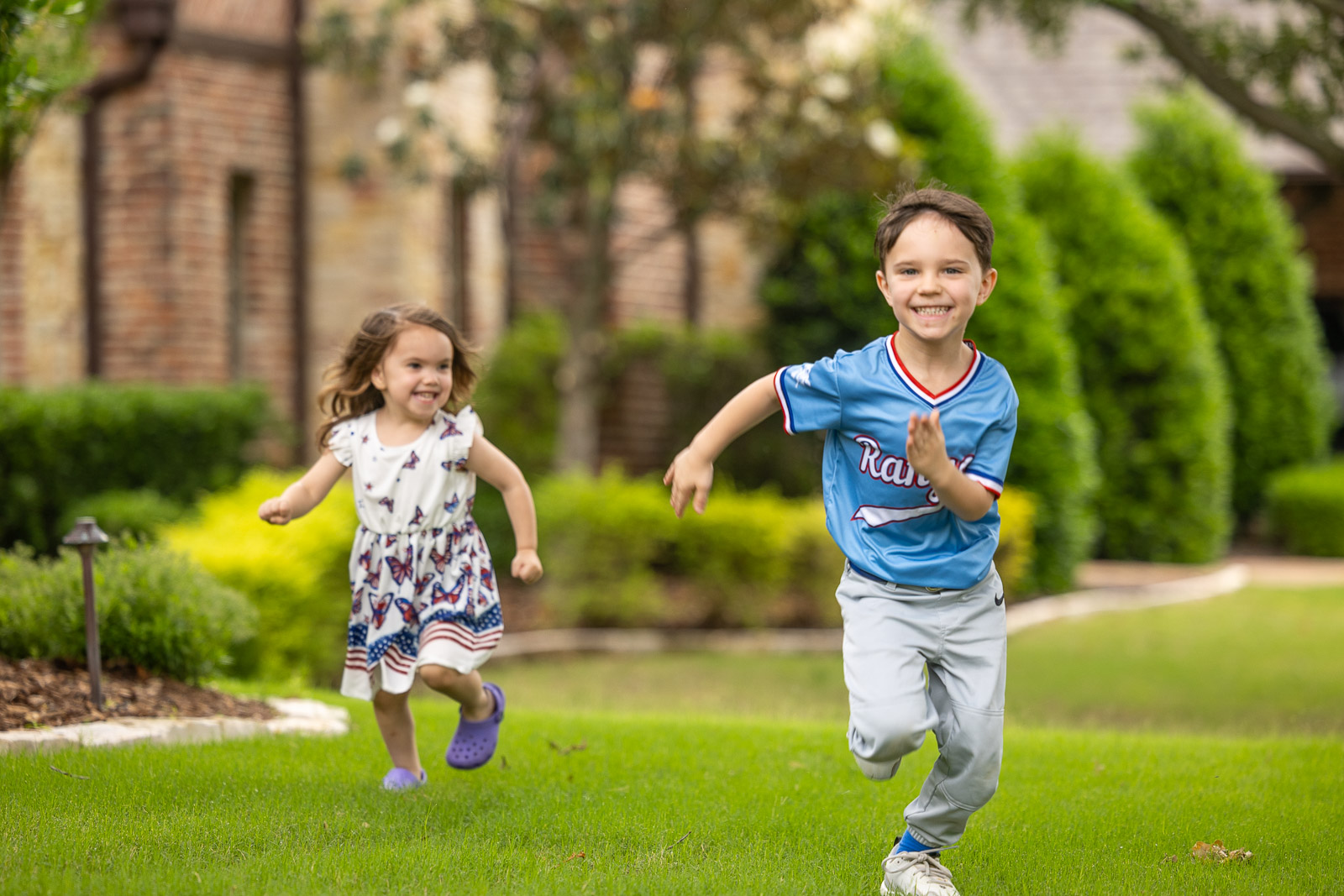 children running on green lawn landscape beds 1