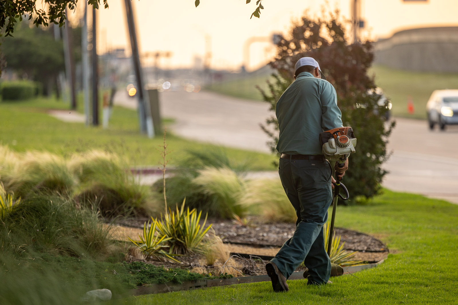 landscape maintenance crew weed wacking landscape beds 