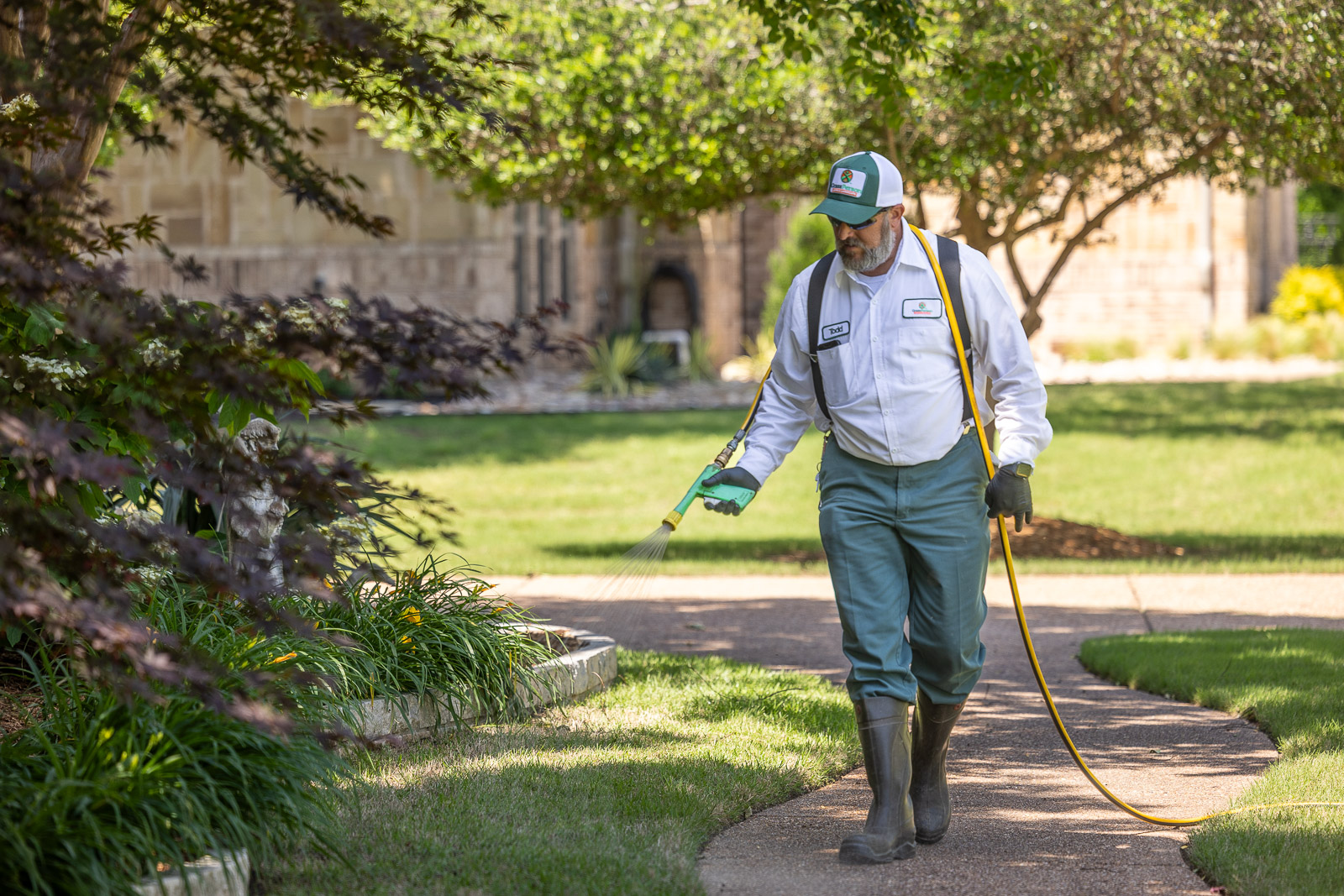 lawn care technicial putting down weed control on grass 3