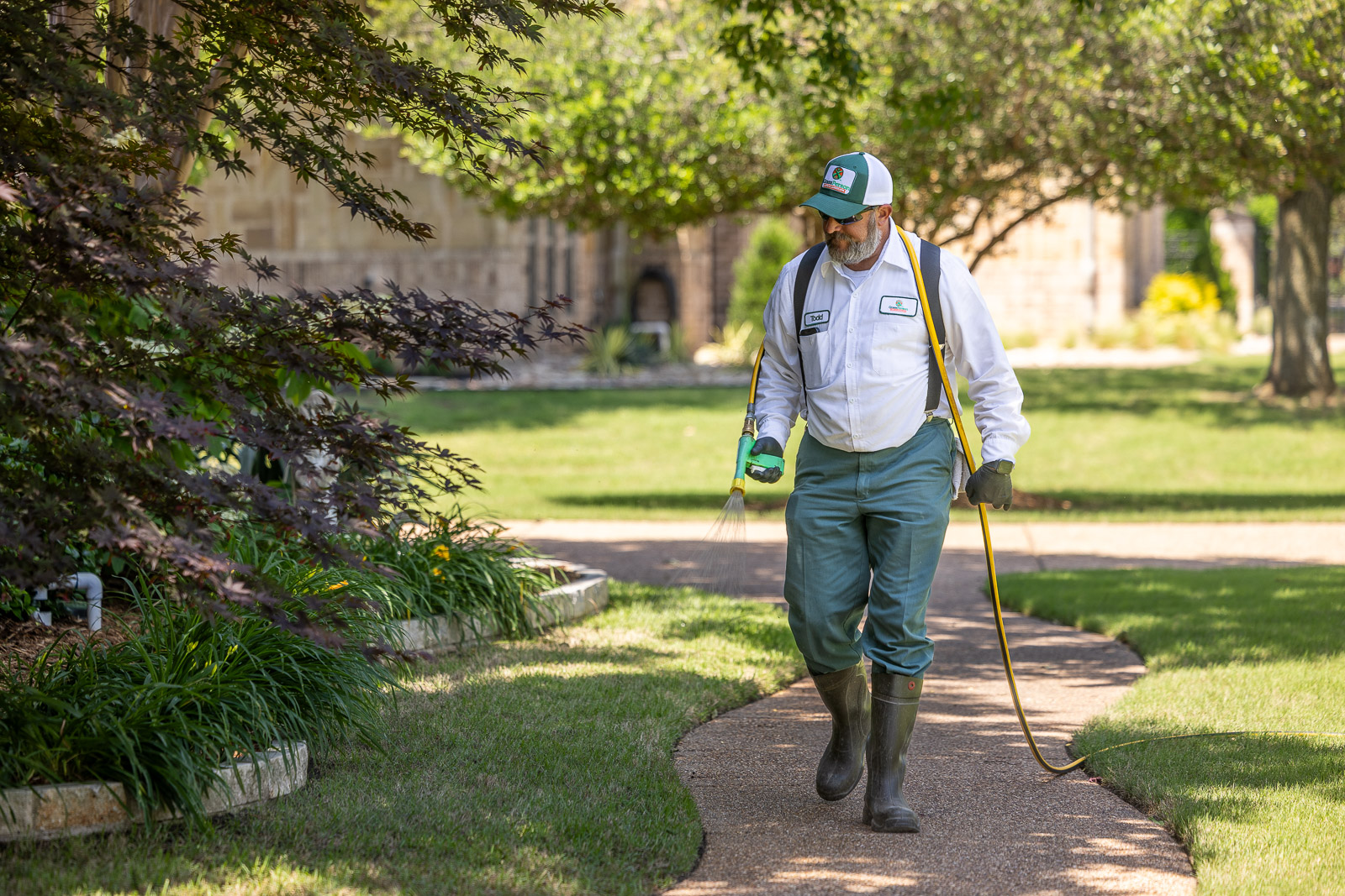 lawn care technicial putting down weed control on grass 4