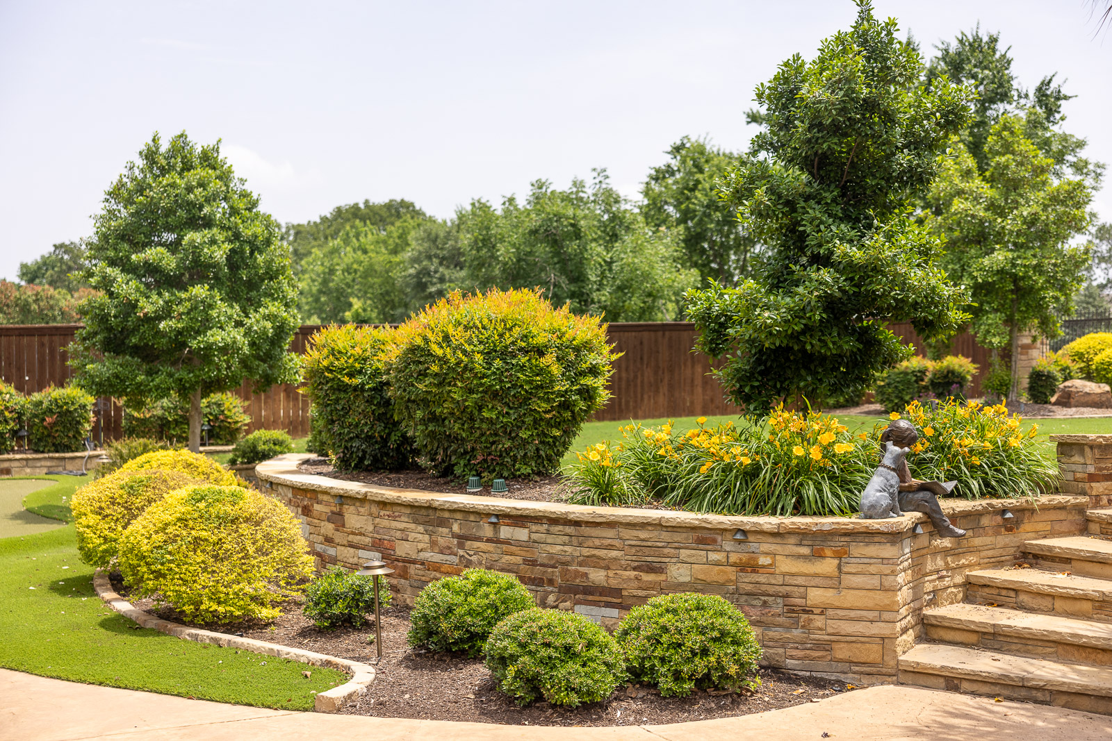 tiered landscape beds retaining wall steps green lawn 